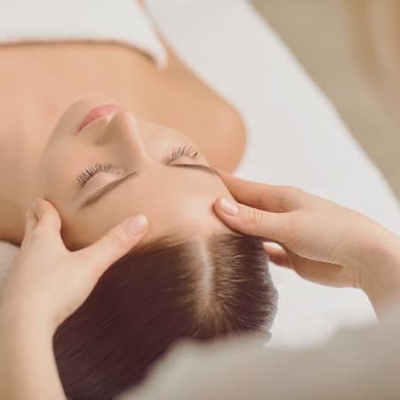 Face massage close up. Beautiful girl has a facial massage in a beauty salon.