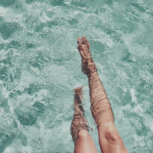 Woman putting her legs in the pool